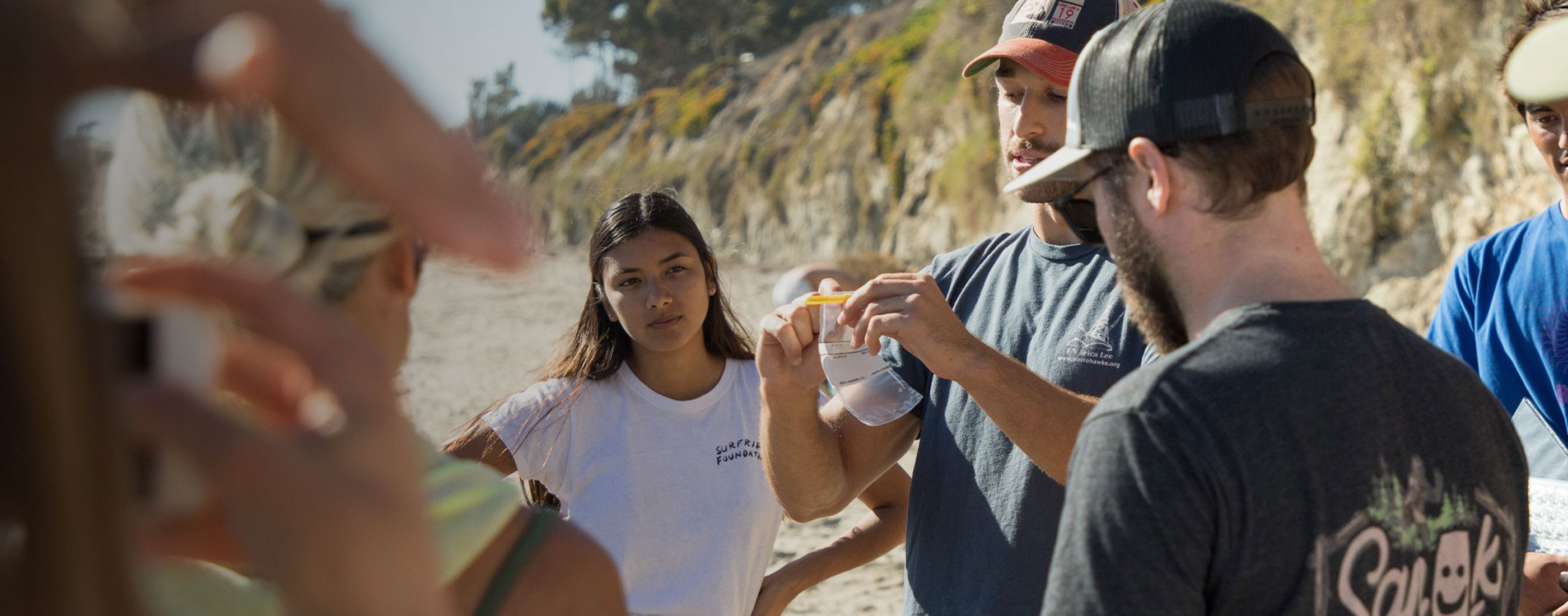 Volunteers gathering around water sample